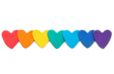 Photo of Colorful hearts made of modeling clay on white background, top view. Rainbow palette