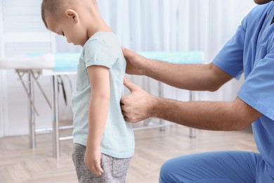 Photo of Orthopedist examining child's back in clinic, closeup. Scoliosis treatment