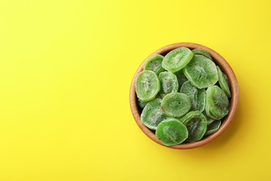 Photo of Bowl of dried kiwi on color background, top view with space for text. Tasty and healthy fruit