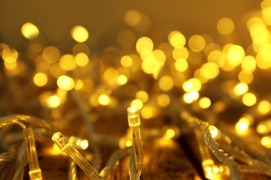 Photo of Glowing Christmas lights on table, closeup view