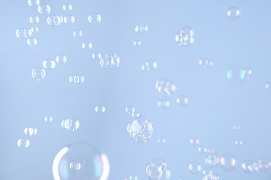 Beautiful transparent soap bubbles on light grey background