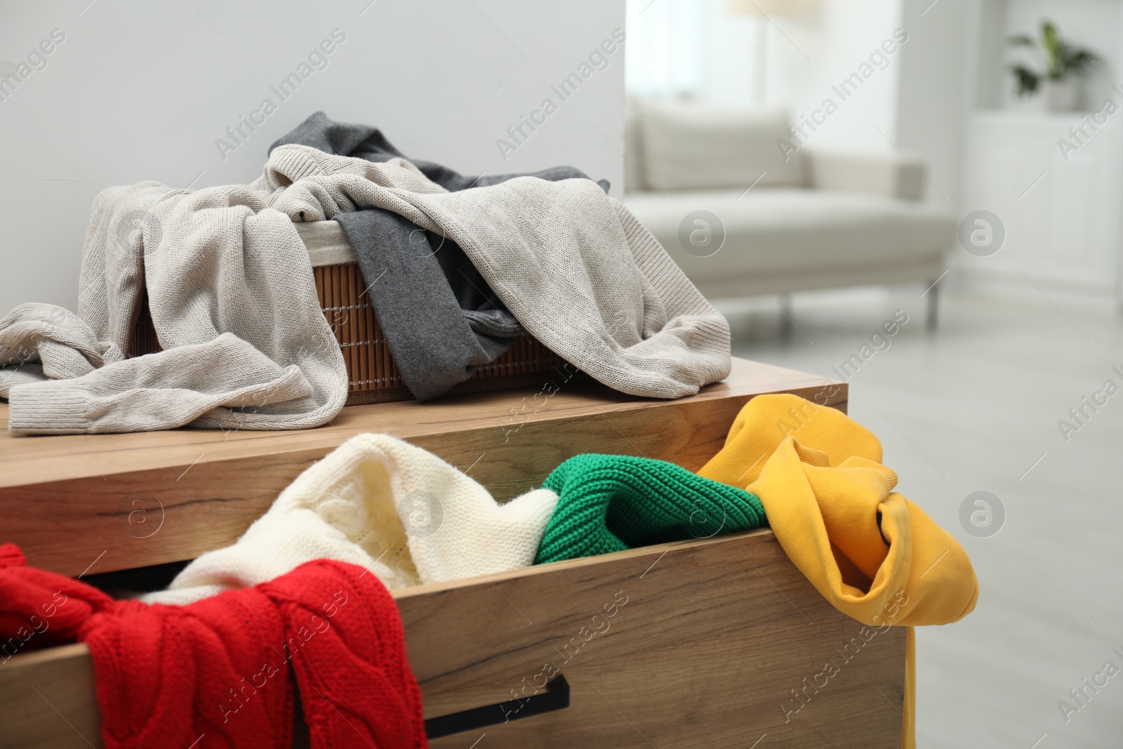 Photo of Cluttered chest of drawers indoors. Clothes in mess