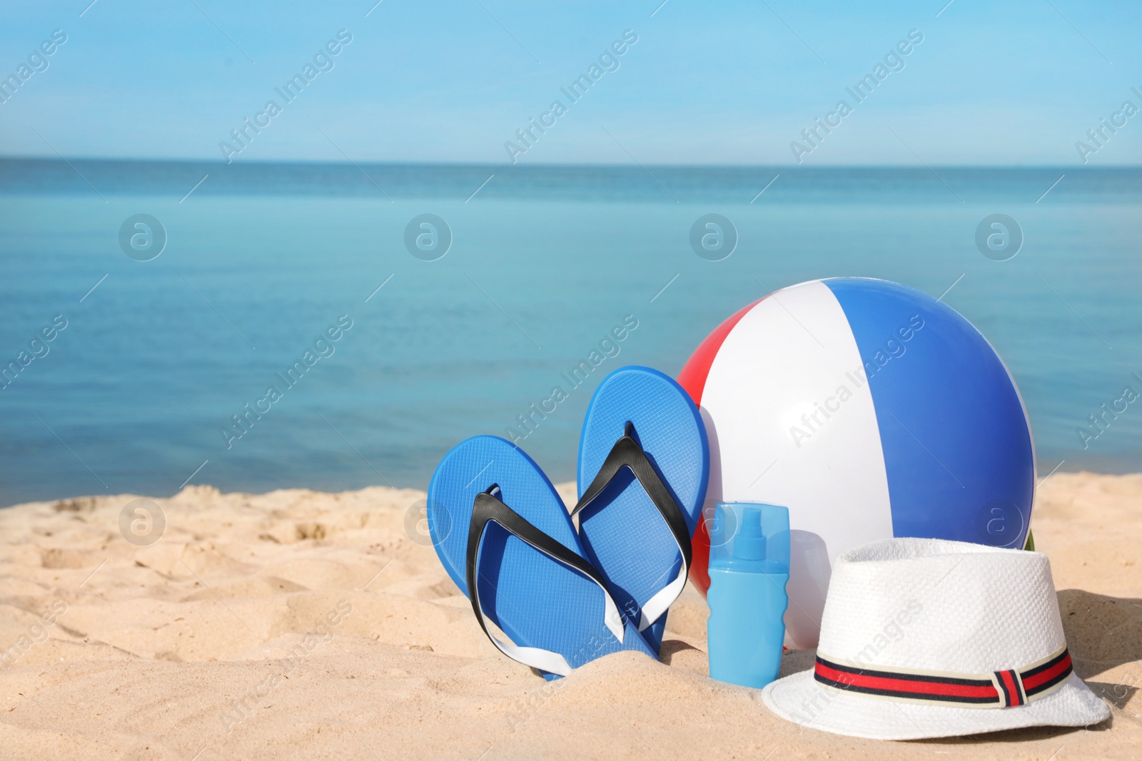 Photo of Beach accessories on sand near sea. Space for text