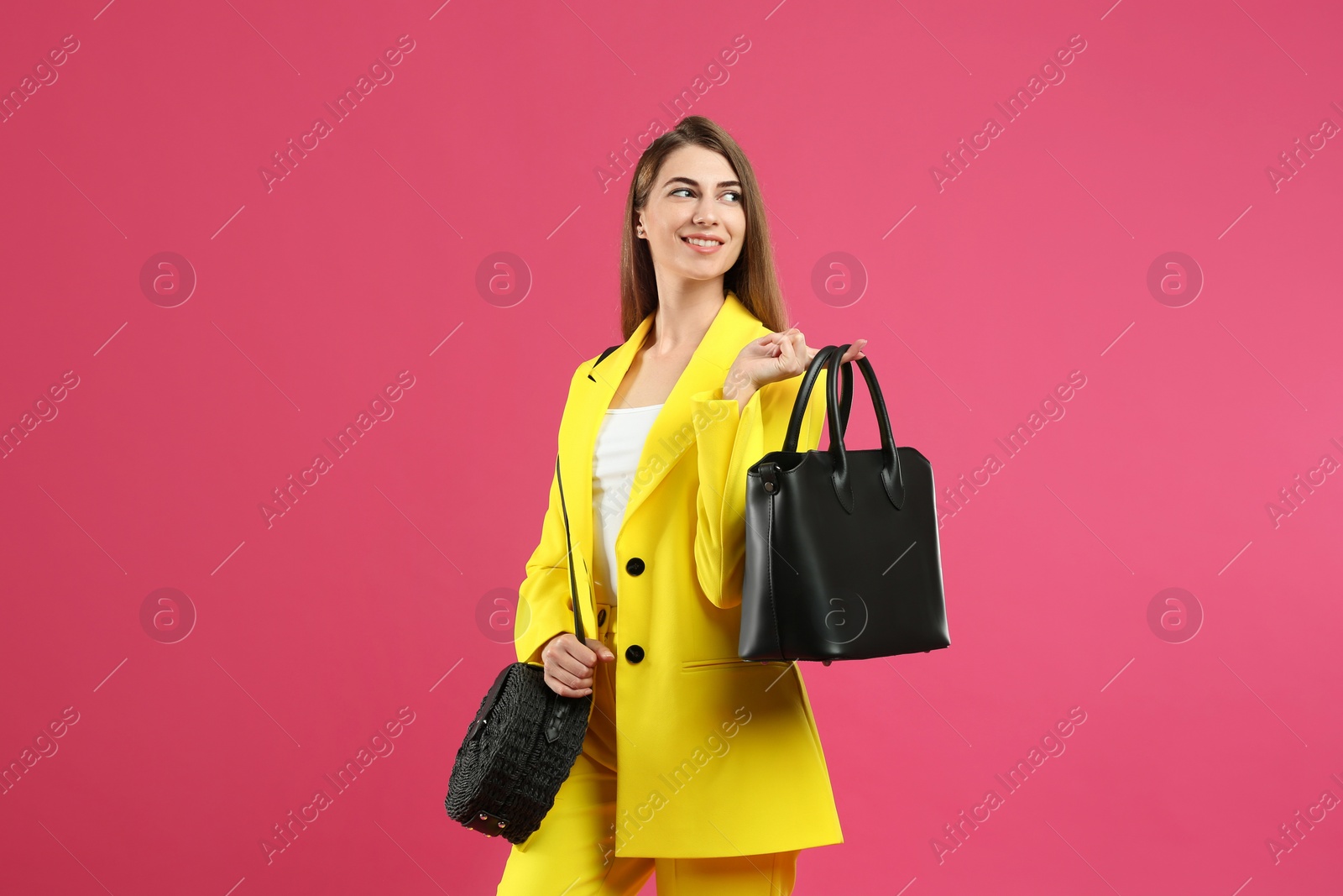 Photo of Beautiful young woman with stylish bags on pink background