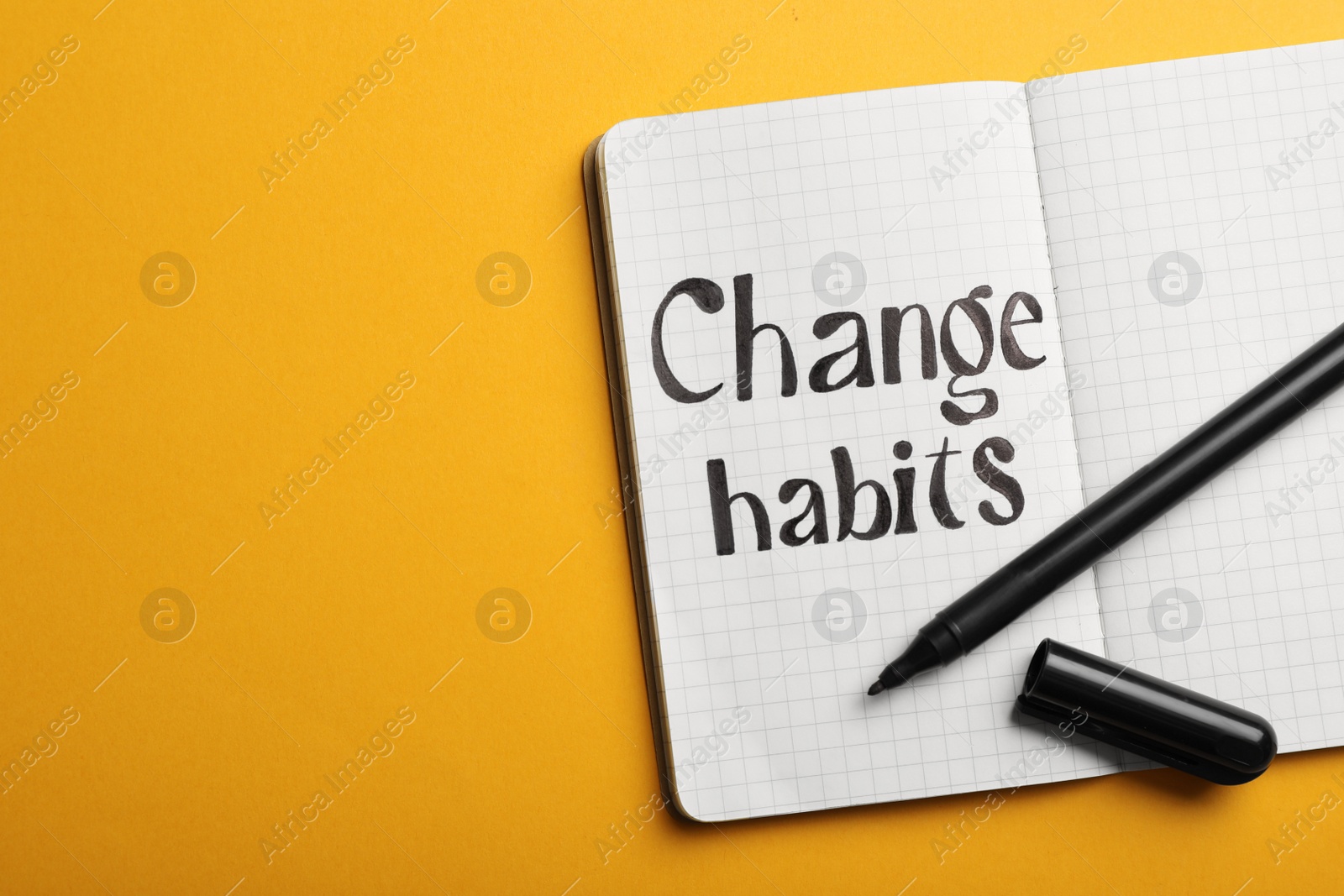 Photo of Open notebook with phrase Change Habits on orange background, top view. Space for text