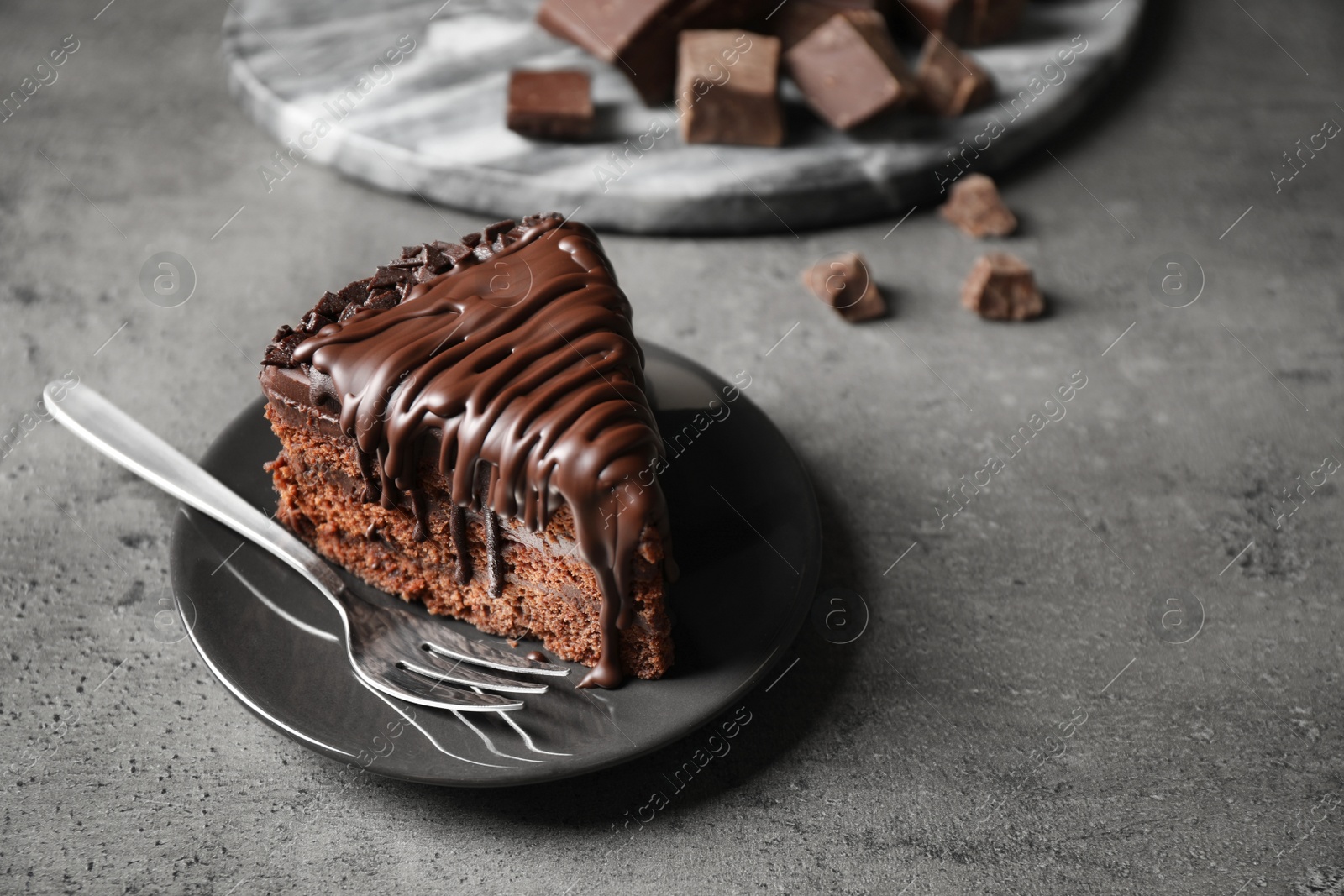 Photo of Tasty chocolate cake served on grey table. Space for text