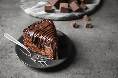 Photo of Tasty chocolate cake served on grey table. Space for text