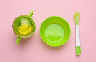 Set of plastic dishware on pink background, flat lay. Serving baby food