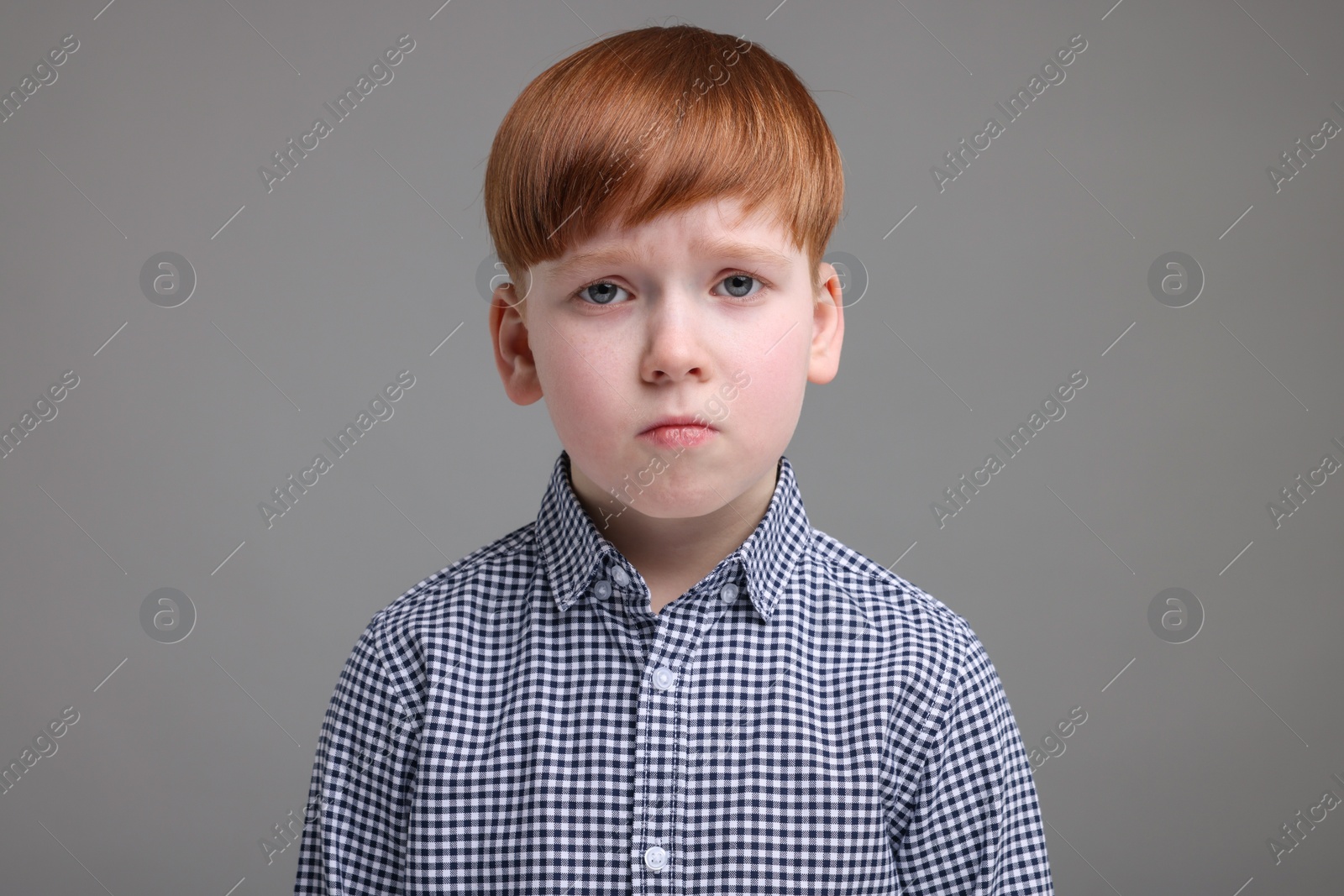 Photo of Portrait of sad little boy on grey background