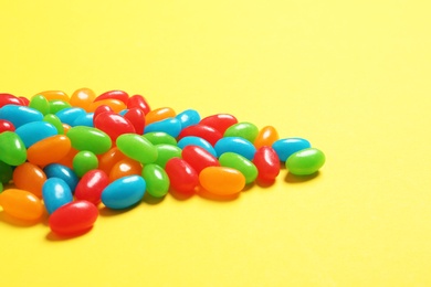 Photo of Delicious bright jelly beans on color background