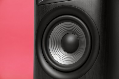 Photo of One wooden sound speaker on red background, closeup