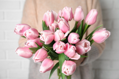 Woman with beautiful pink spring tulips on white background, closeup