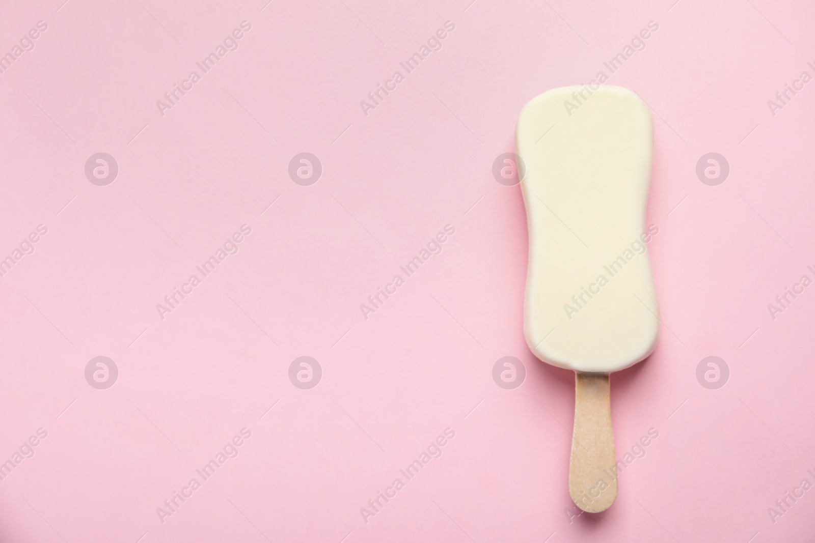 Photo of Ice cream with glaze on pink background, top view. Space for text
