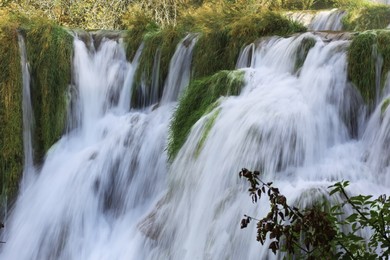 Photo of Picturesque view of beautiful waterfall and rocks outdoors