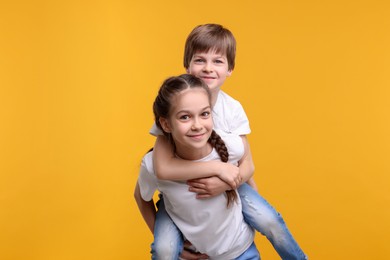 Photo of Happy brother and sister on orange background