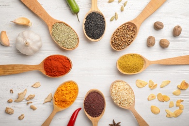 Photo of Flat lay composition with different aromatic spices in spoons on wooden background