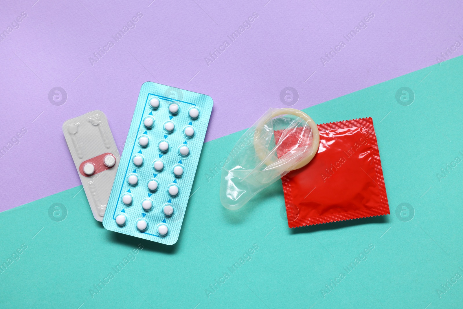 Photo of Condoms and contraception pills on color background, flat lay. Choosing birth control method