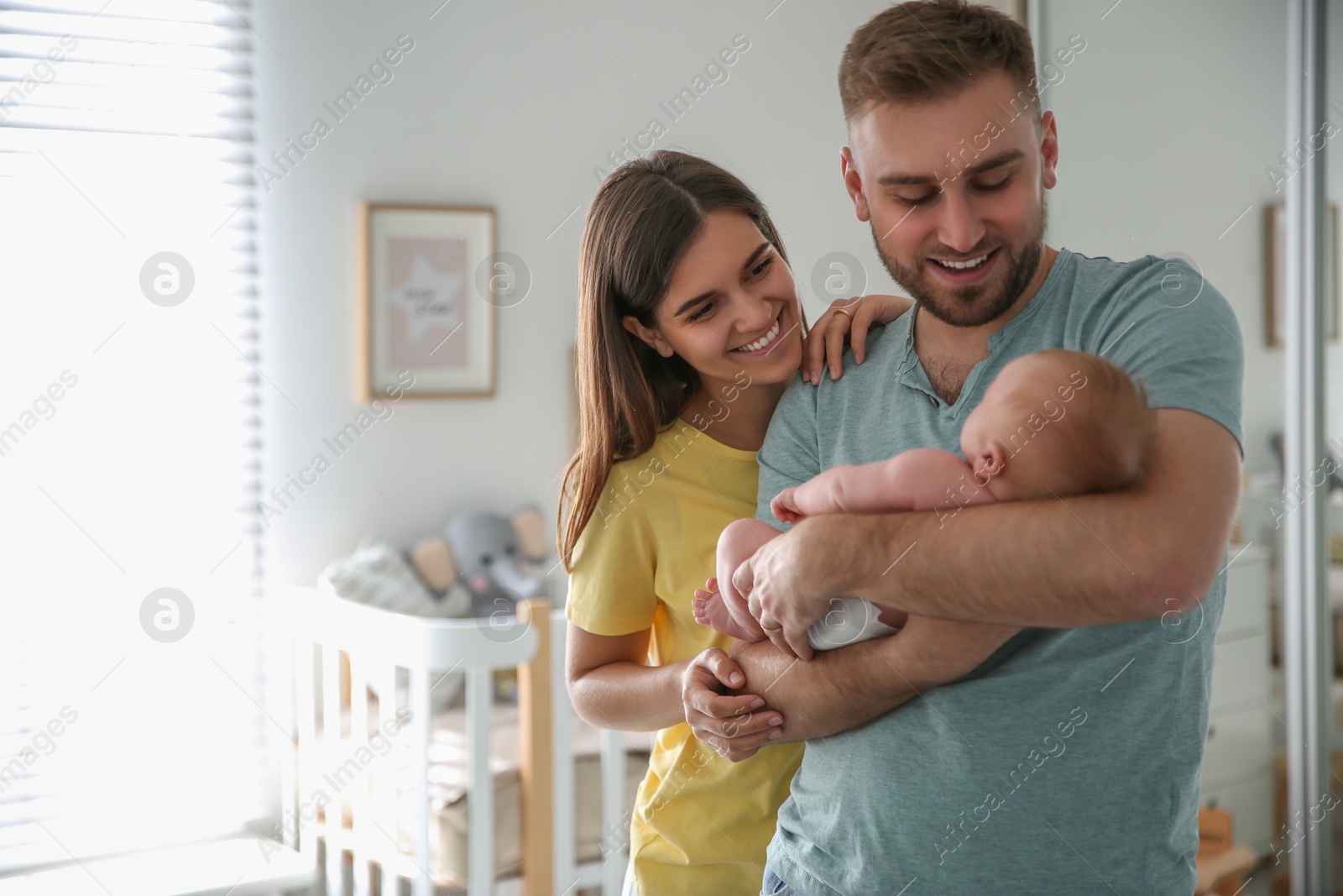 Photo of Happy couple with their newborn baby at home. Space for text