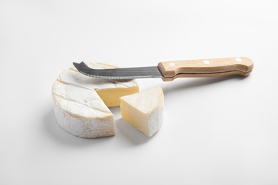 Photo of Cut Camembert cheese and knife on white background