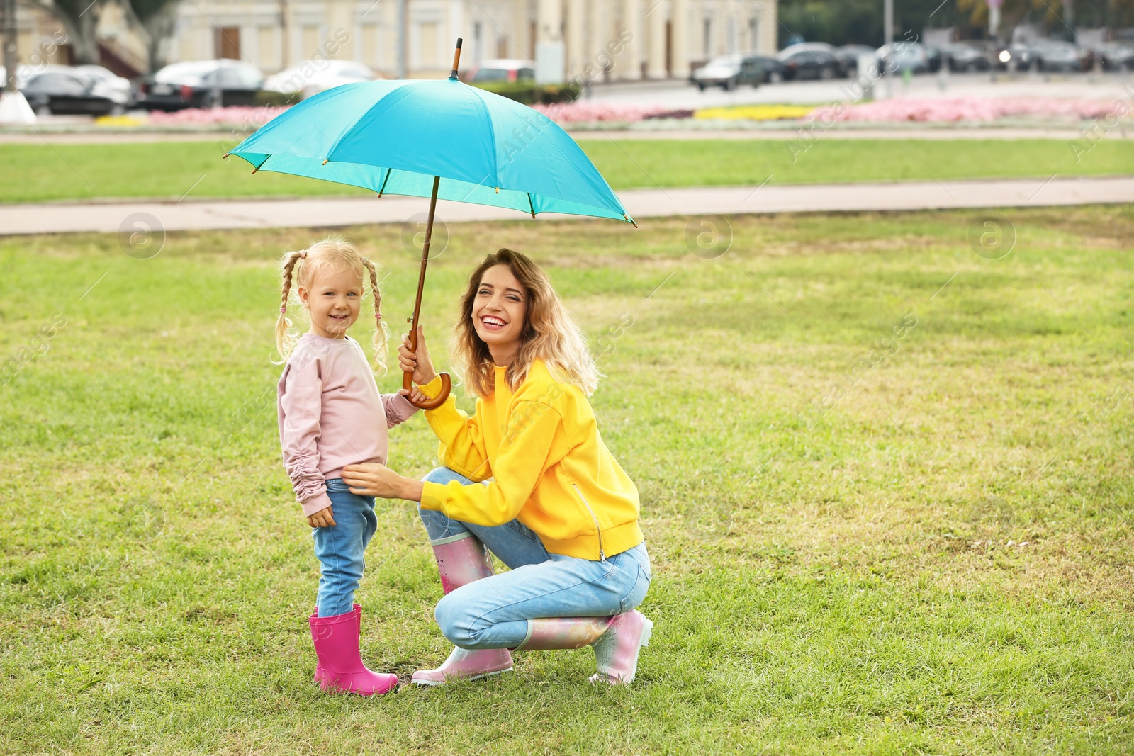 Photo of Happy mother and daughter with umbrella in park