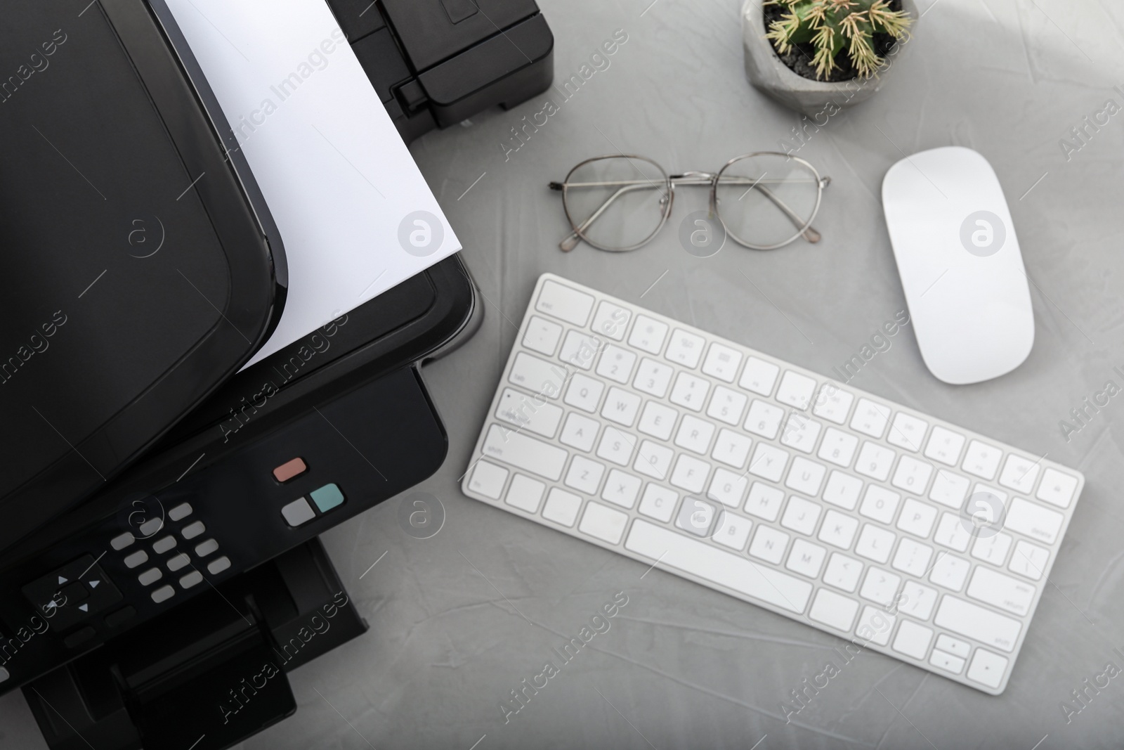 Photo of Modern printer, computer keyboard and mouse on grey table, flat lay