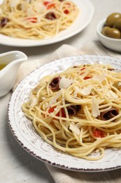 Delicious pasta with anchovies, tomatoes and parmesan cheese on light grey table