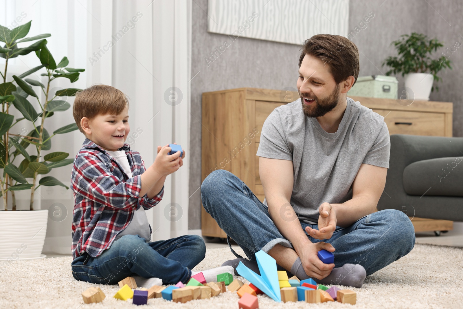 Photo of Happy dad and son playing with cubes at home