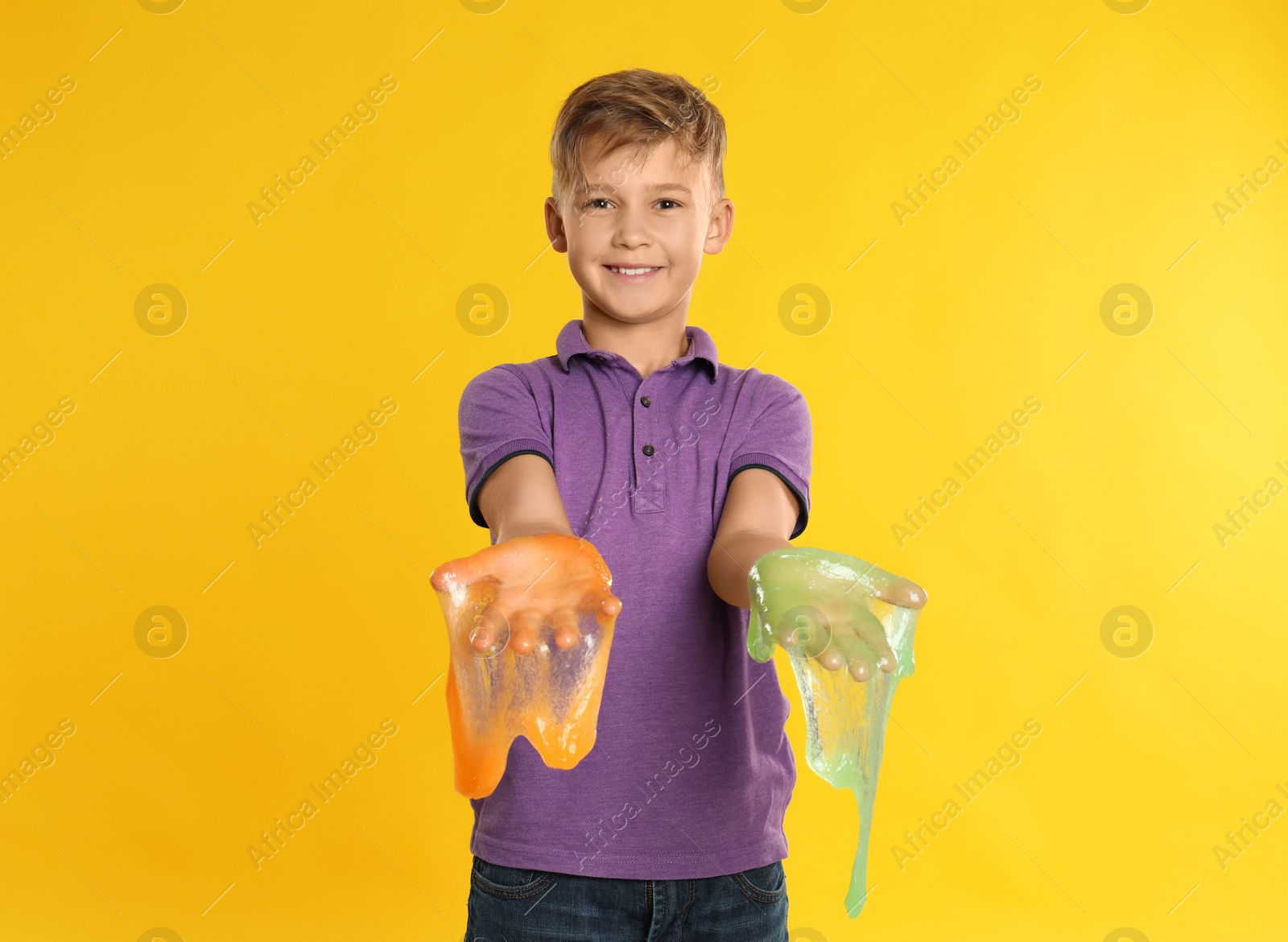 Photo of Preteen boy with slime on yellow background