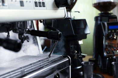 Photo of Modern coffee machine in cafe, closeup. Space for text