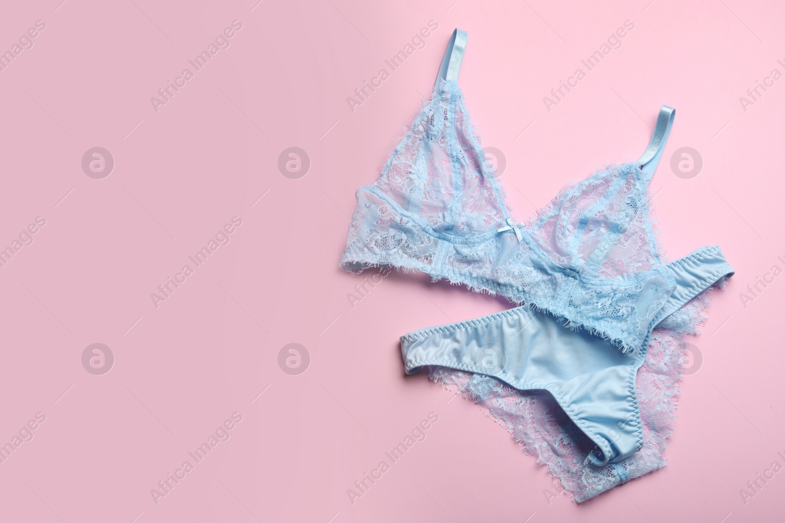 Photo of Elegant women's underwear on pink background, flat lay. Space for text