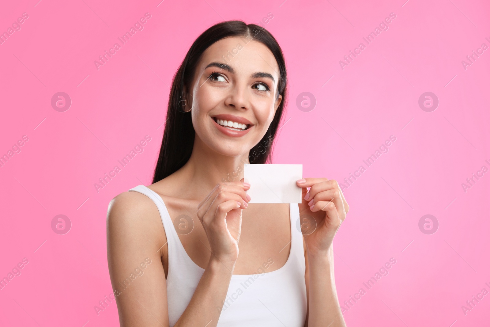 Photo of Beautiful woman with mattifying wipe on pink background