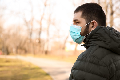 Photo of Man wearing disposable mask outdoors. Dangerous virus
