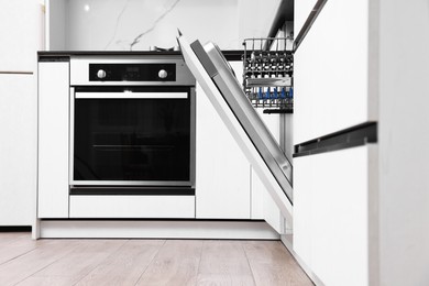 Photo of Built-in dishwasher with open door in kitchen