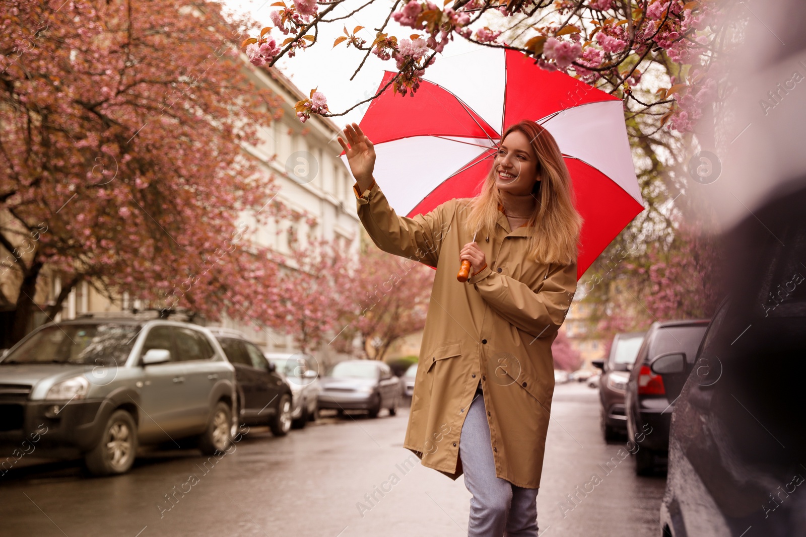 Photo of Young woman with umbrella walking on spring day