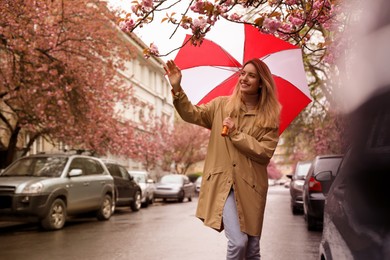 Young woman with umbrella walking on spring day