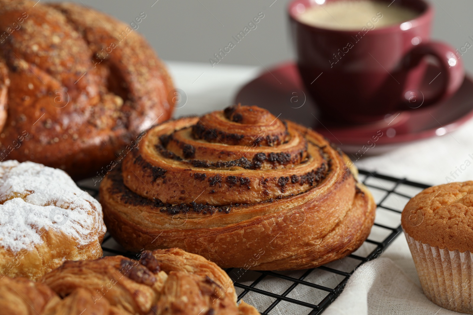 Photo of Tasty freshly baked spiral pastry on cooling rack, closeup