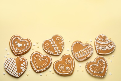 Photo of Tasty heart shaped gingerbread cookies on yellow background, flat lay. Space for text