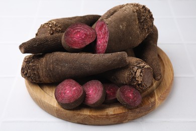 Photo of Whole and cut red beets on white table, closeup