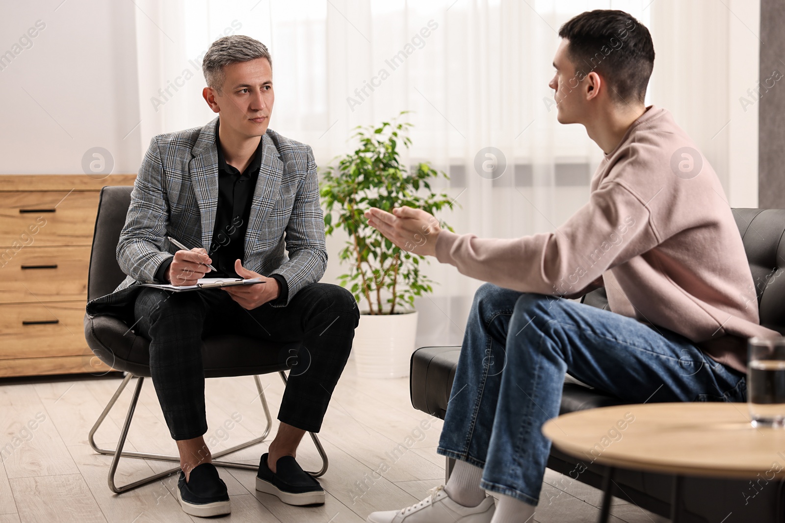 Photo of Professional psychotherapist working with patient in office