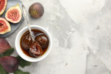 Bowl of tasty sweet jam and fresh figs on grey table, flat lay. Space for text