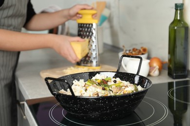 Woman cooking delicious risotto, closeup. Tasty recipe