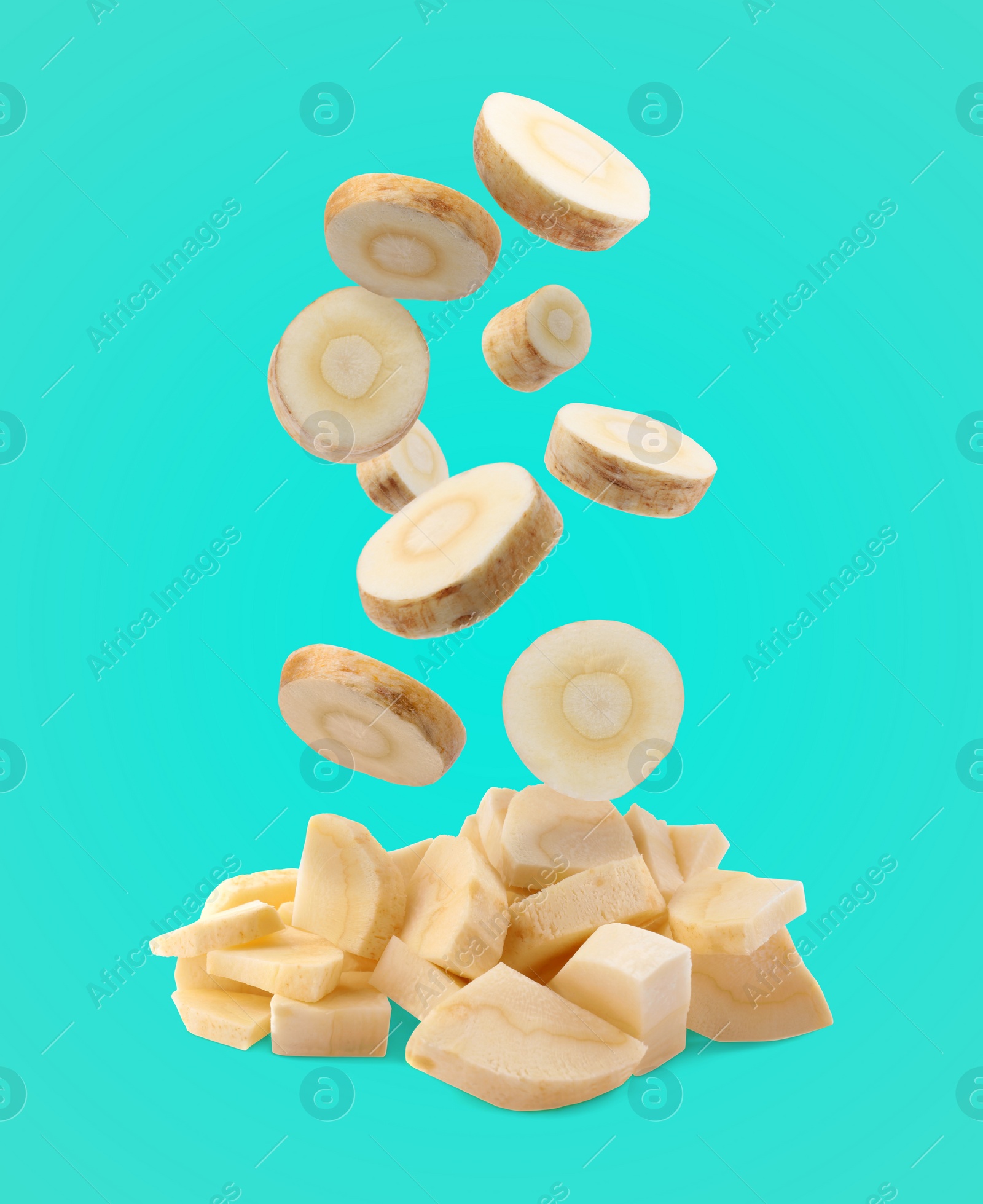 Image of Pieces of parsnip root falling into pile on turquoise background