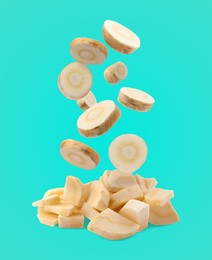Image of Pieces of parsnip root falling into pile on turquoise background