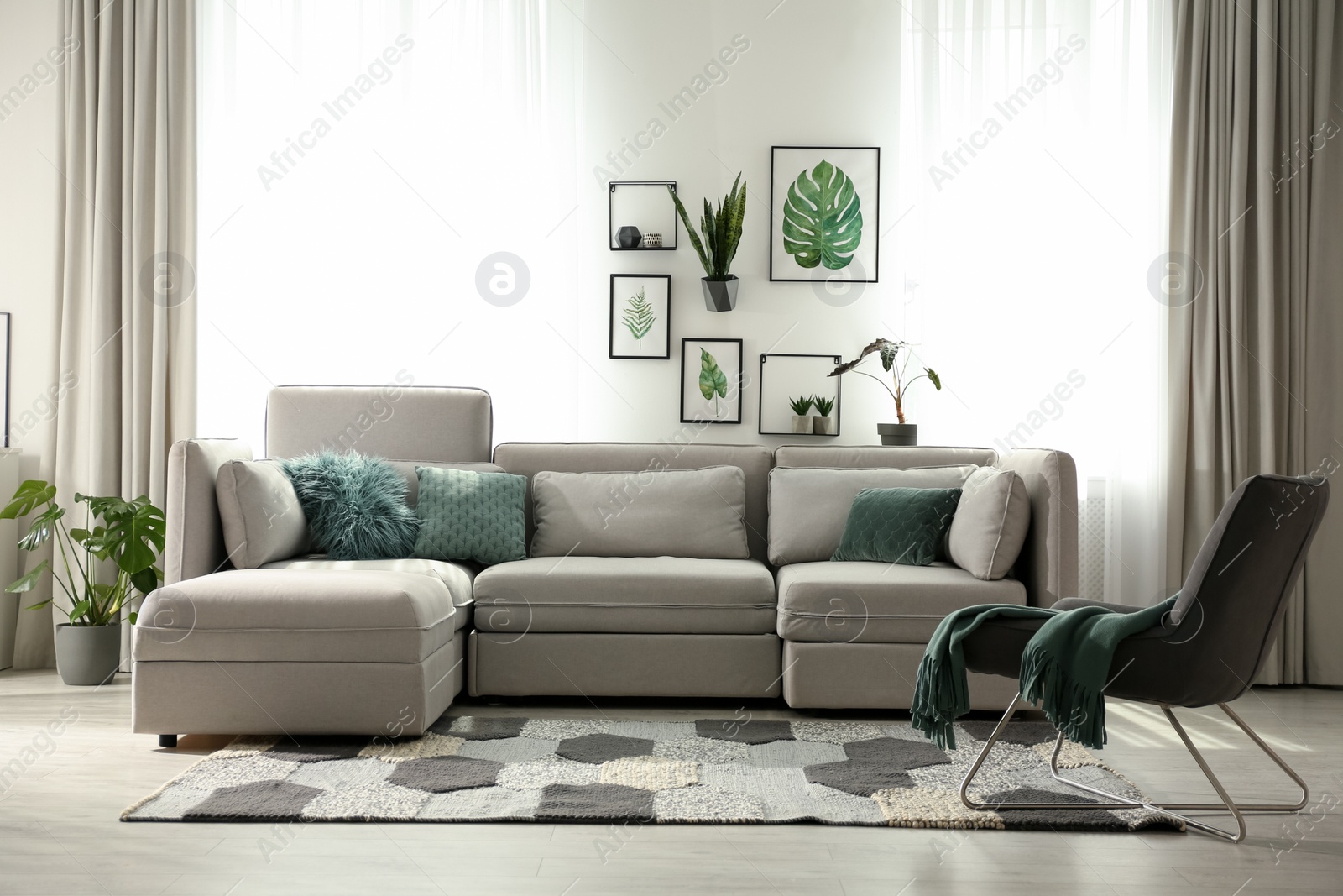 Photo of Comfortable large sofa in light room. Interior design