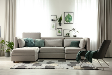 Photo of Comfortable large sofa in light room. Interior design