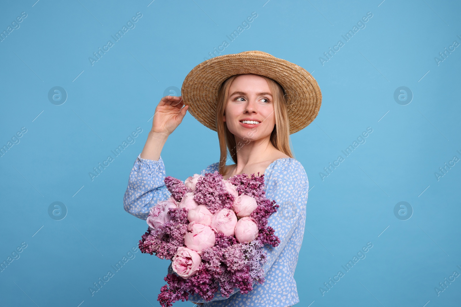 Photo of Beautiful woman with bouquet of spring flowers on light blue background