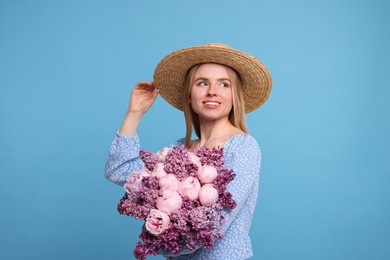 Beautiful woman with bouquet of spring flowers on light blue background