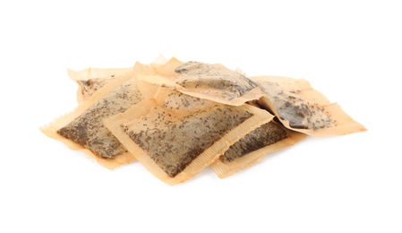 Photo of Many used tea bags on white background