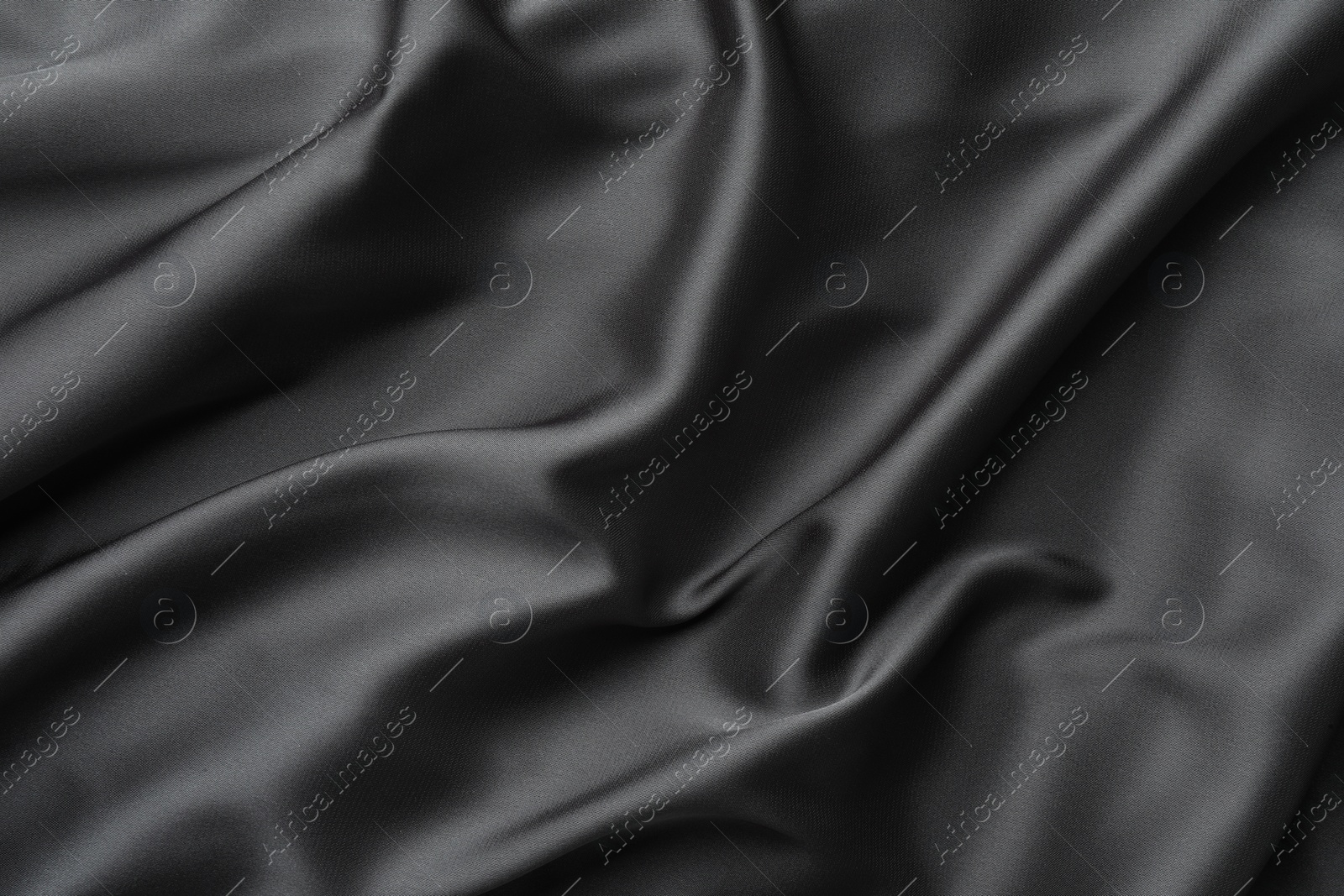 Photo of Texture of black crumpled silk fabric as background, closeup