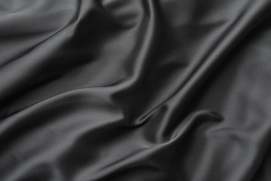 Photo of Texture of black crumpled silk fabric as background, closeup